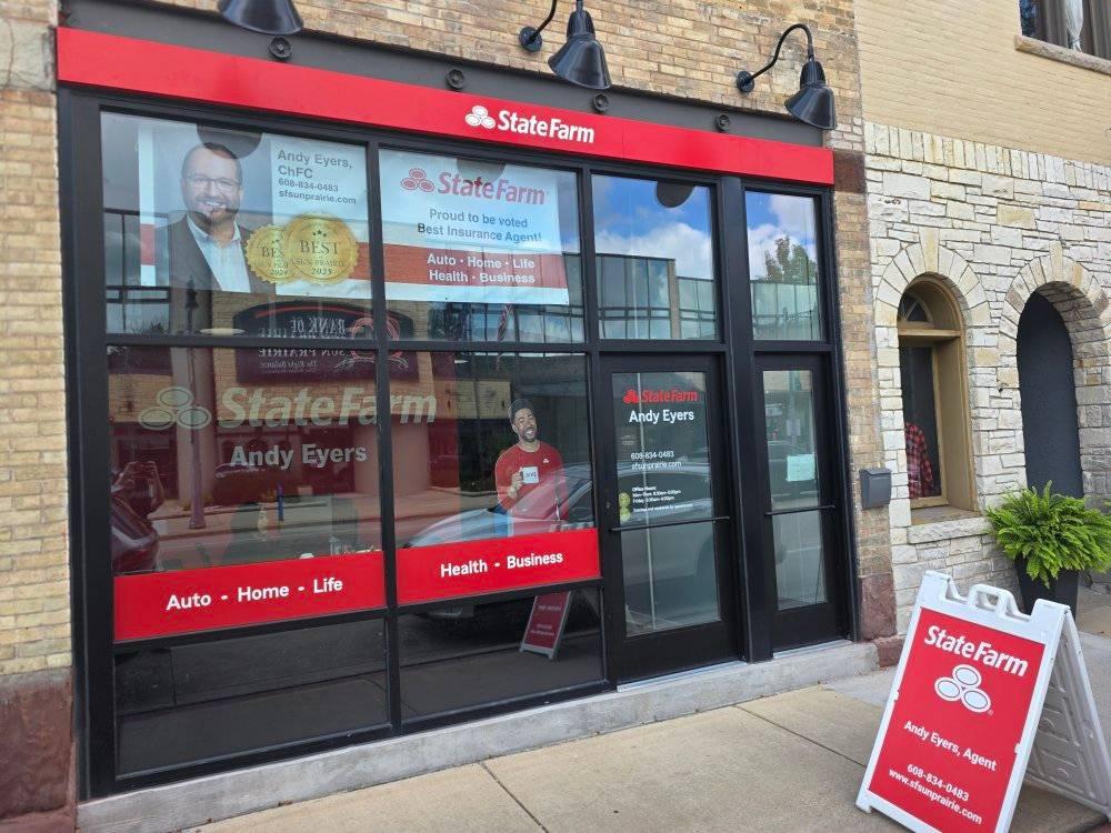 State Farm insurance office storefront with large windows displaying signs for Andy Eyers, Agent, and an outdoor sign listing insurance services: Auto, Home, Life, Health, and Business.
